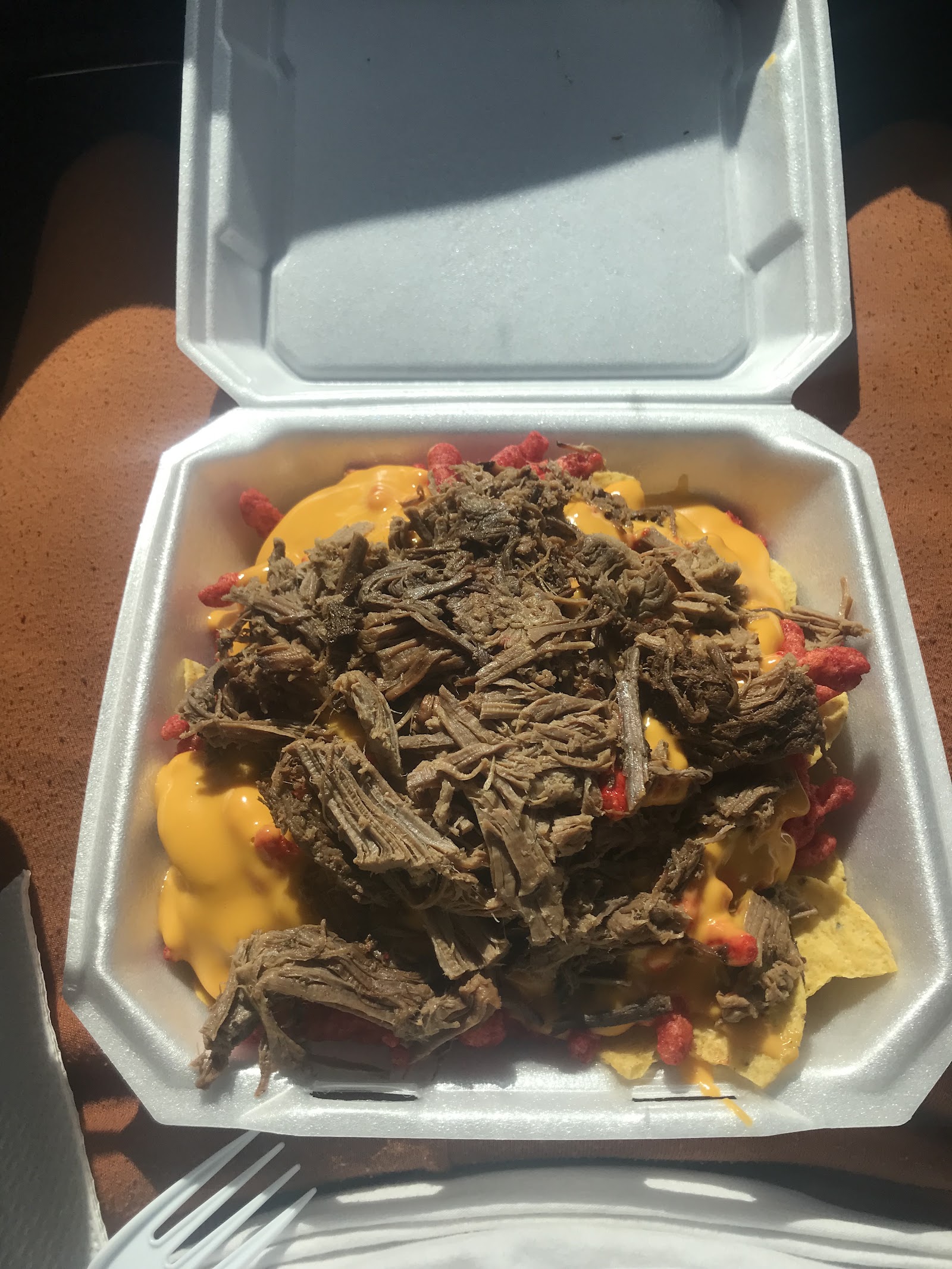 Loaded brisket nachos with cheese sauce and Hot Cheetos