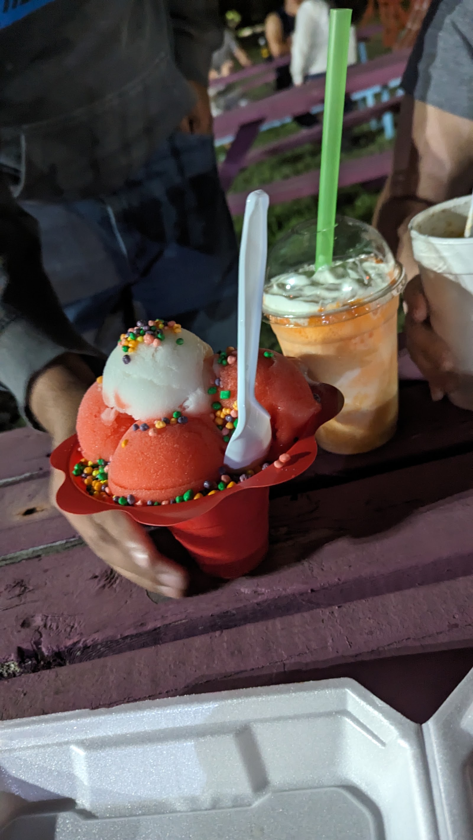 Ice cream scoops with sprinkles beside an iced drink